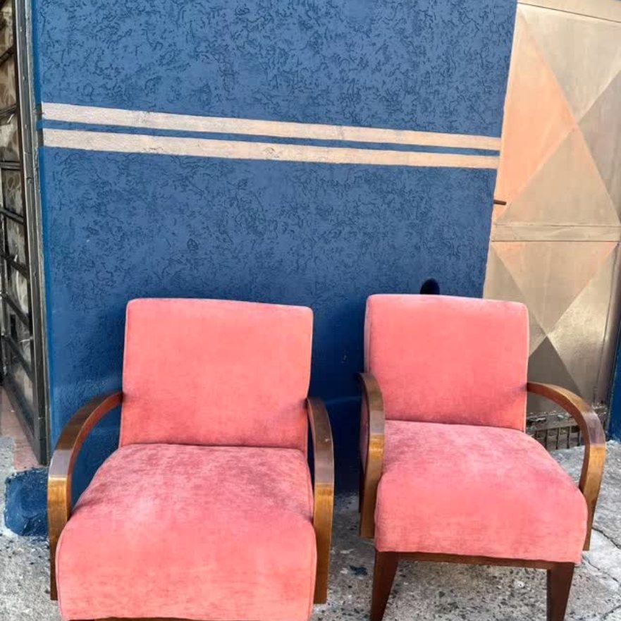 Par de poltronas com braços de madeira e tecido rosa